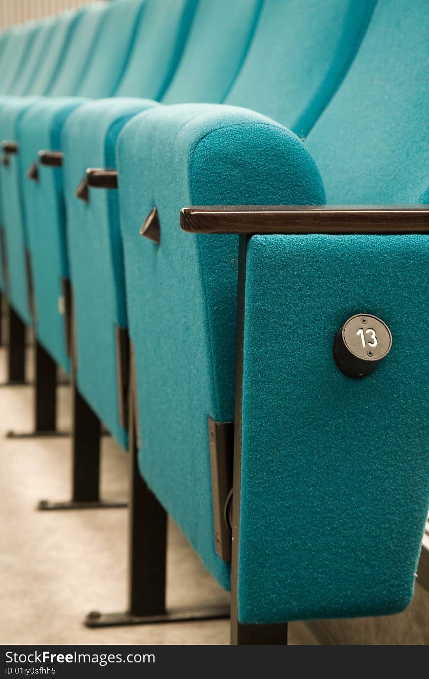 Row number thirteen. Row of green chairs in auditorium. Row number thirteen. Row of green chairs in auditorium.