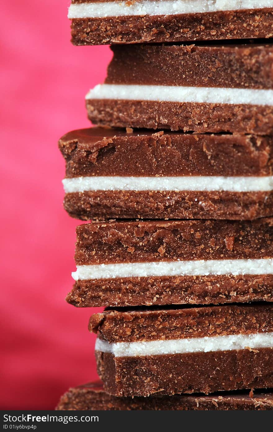 Close-up of chunks of black and white chocolate on vivid pink background. Close-up of chunks of black and white chocolate on vivid pink background