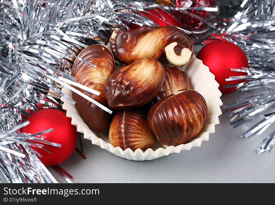 Seashell shaped pralines surrounded by Christmas decoration. Seashell shaped pralines surrounded by Christmas decoration