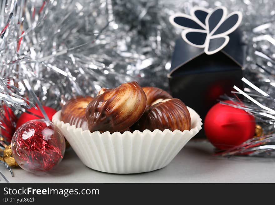 Seashell shaped pralines surrounded by Christmas decoration. Seashell shaped pralines surrounded by Christmas decoration