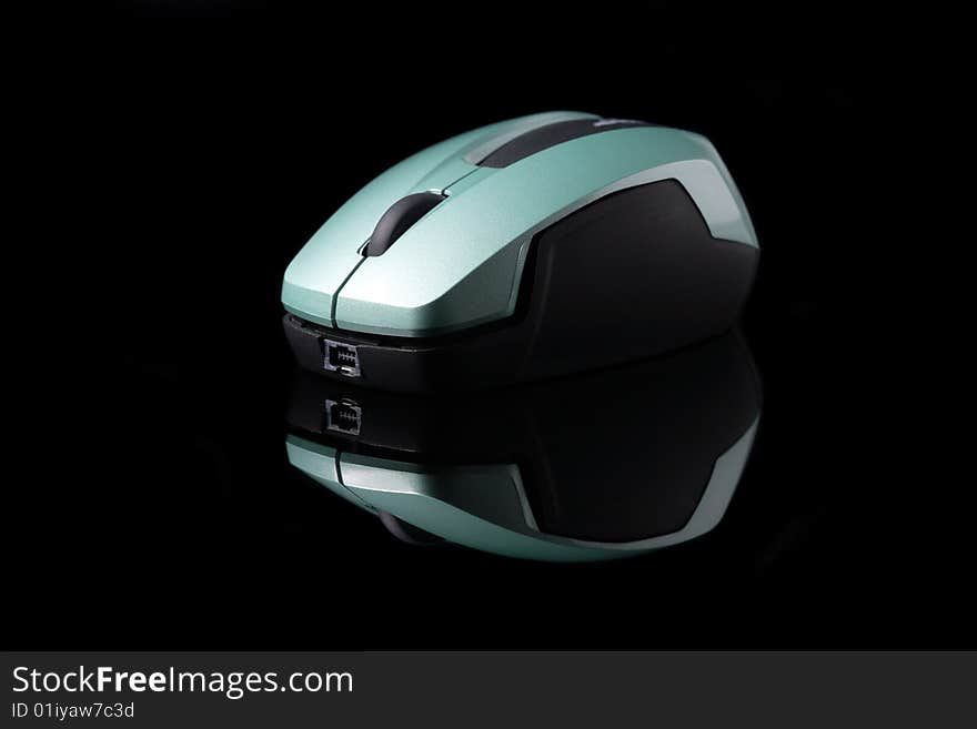 A wireless mouse isolated on black background with mirror reflection.