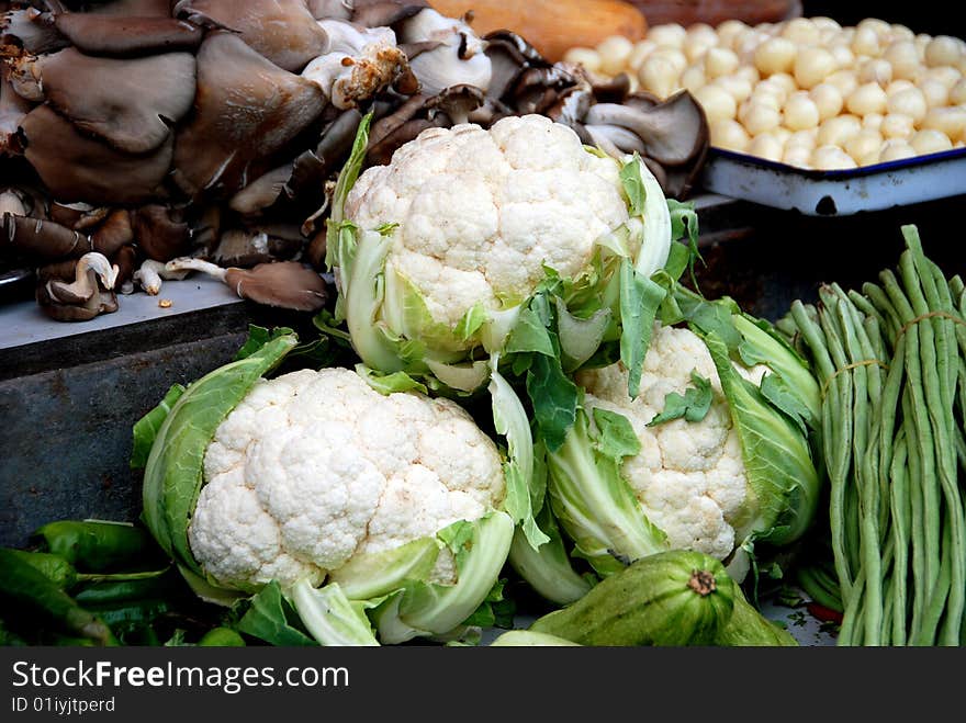 Mushrooms, green beans, garlic, and three large heads of cauliflower at the Tian Fu outdoor market in Pengzhou, Sichuan province, China - Lee Snider Photo. Mushrooms, green beans, garlic, and three large heads of cauliflower at the Tian Fu outdoor market in Pengzhou, Sichuan province, China - Lee Snider Photo.