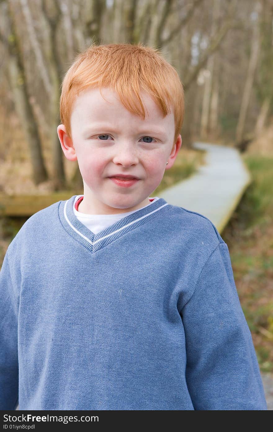 Young boy standing on a path in park. Young boy standing on a path in park