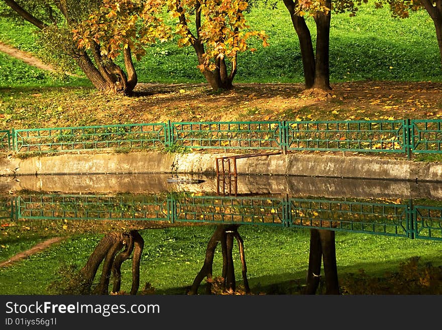 An autumn view of trees reflecting in water. An autumn view of trees reflecting in water