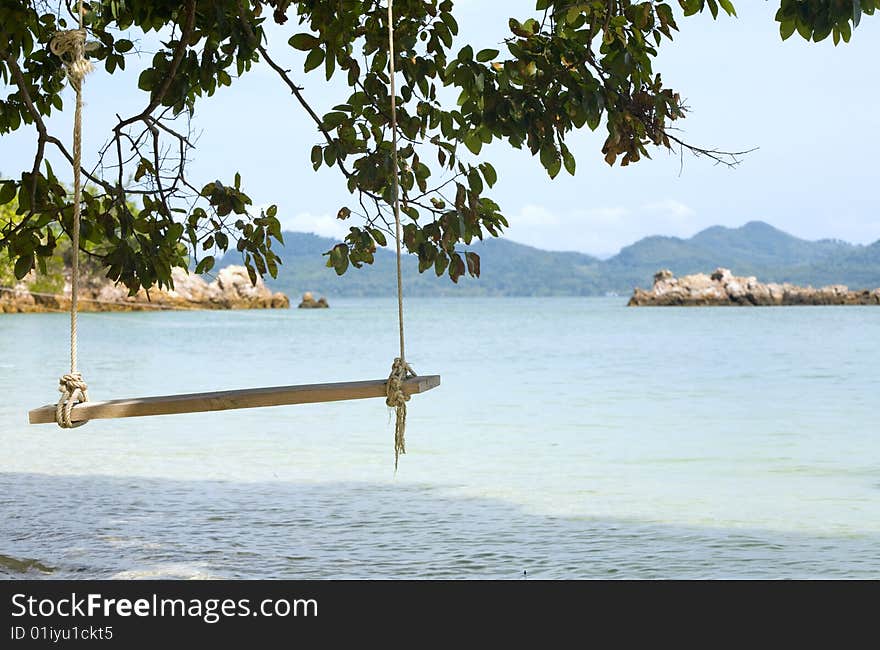 A swing under the trees on a beautiful island. A swing under the trees on a beautiful island