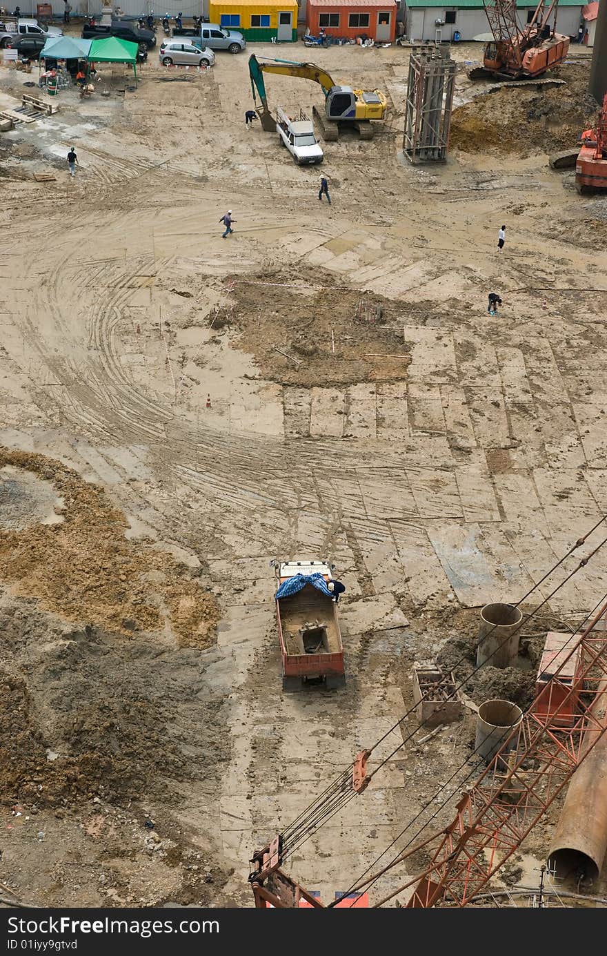 Muddy construction site with machines and trucks