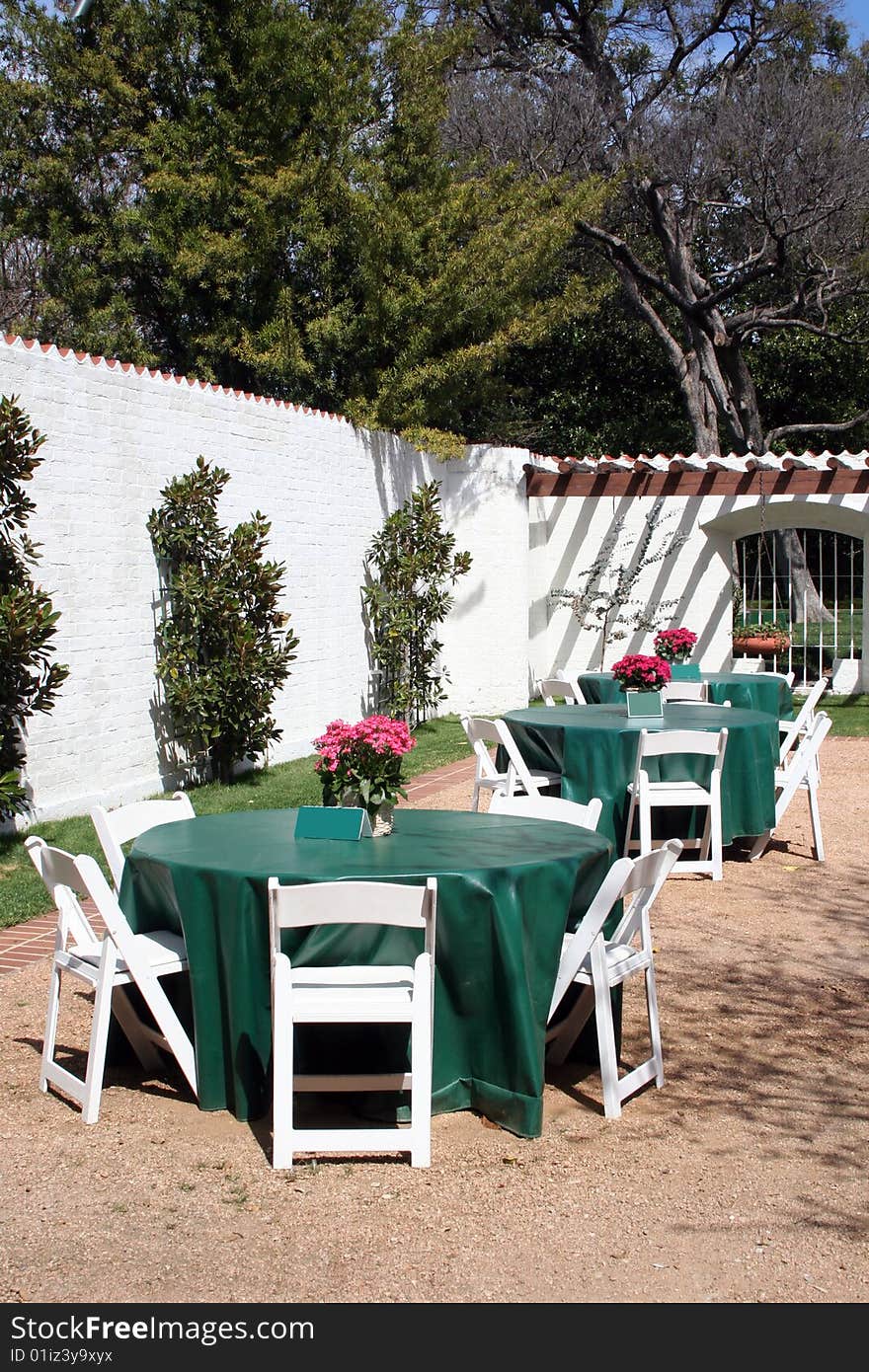 Several tables are in an outdoor patio area waiting for guests to dine. Several tables are in an outdoor patio area waiting for guests to dine.