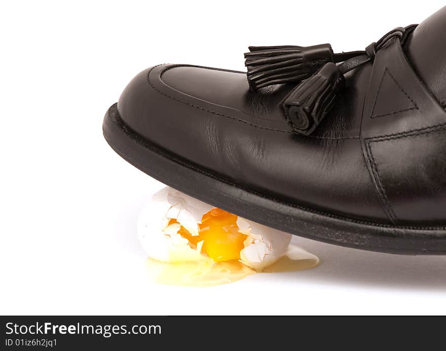 Dress shoe walking on egg shells representing tension or making a big mess.