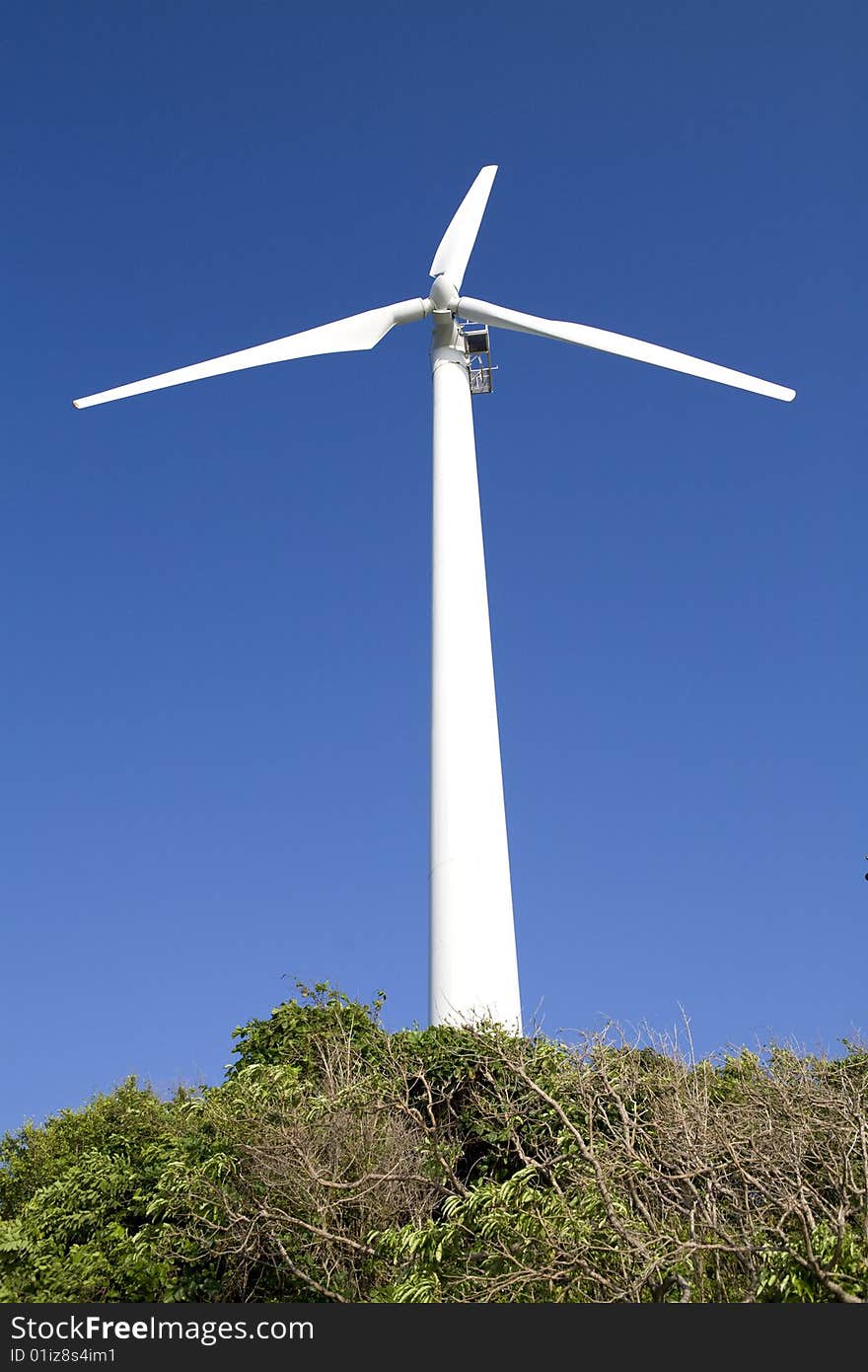 A white wind generator and blue sky. A white wind generator and blue sky