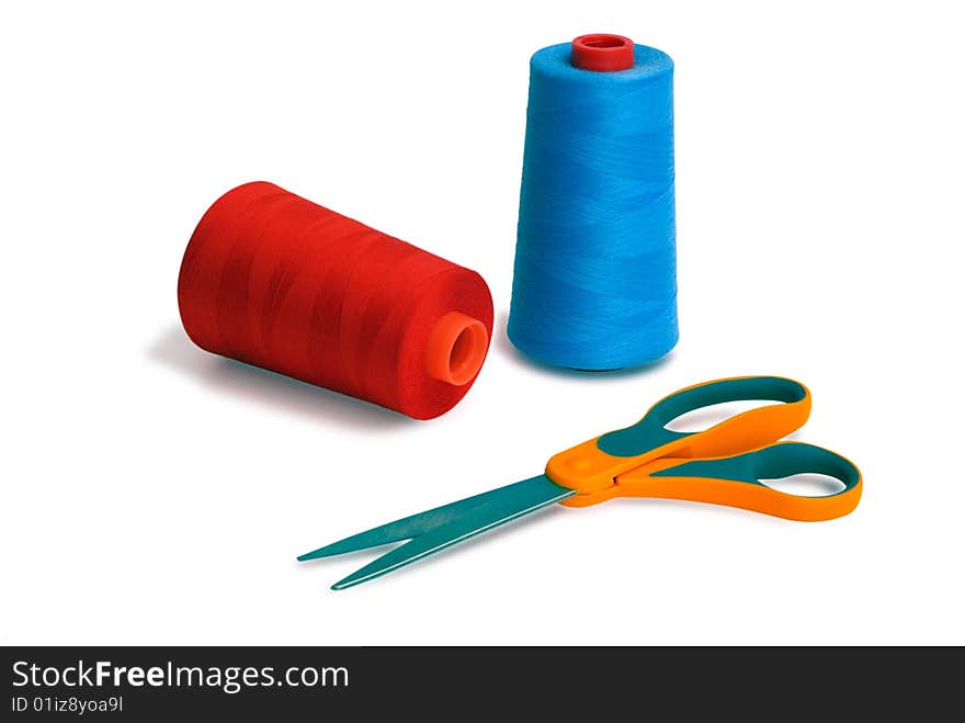 Spools and scissors against white background