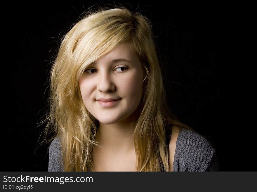 Portrait of young beautiful teenage girl on black background