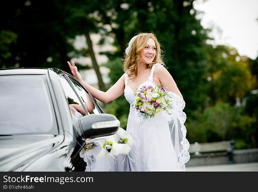 On the image there is bride. She is near car. On the image there is bride. She is near car.