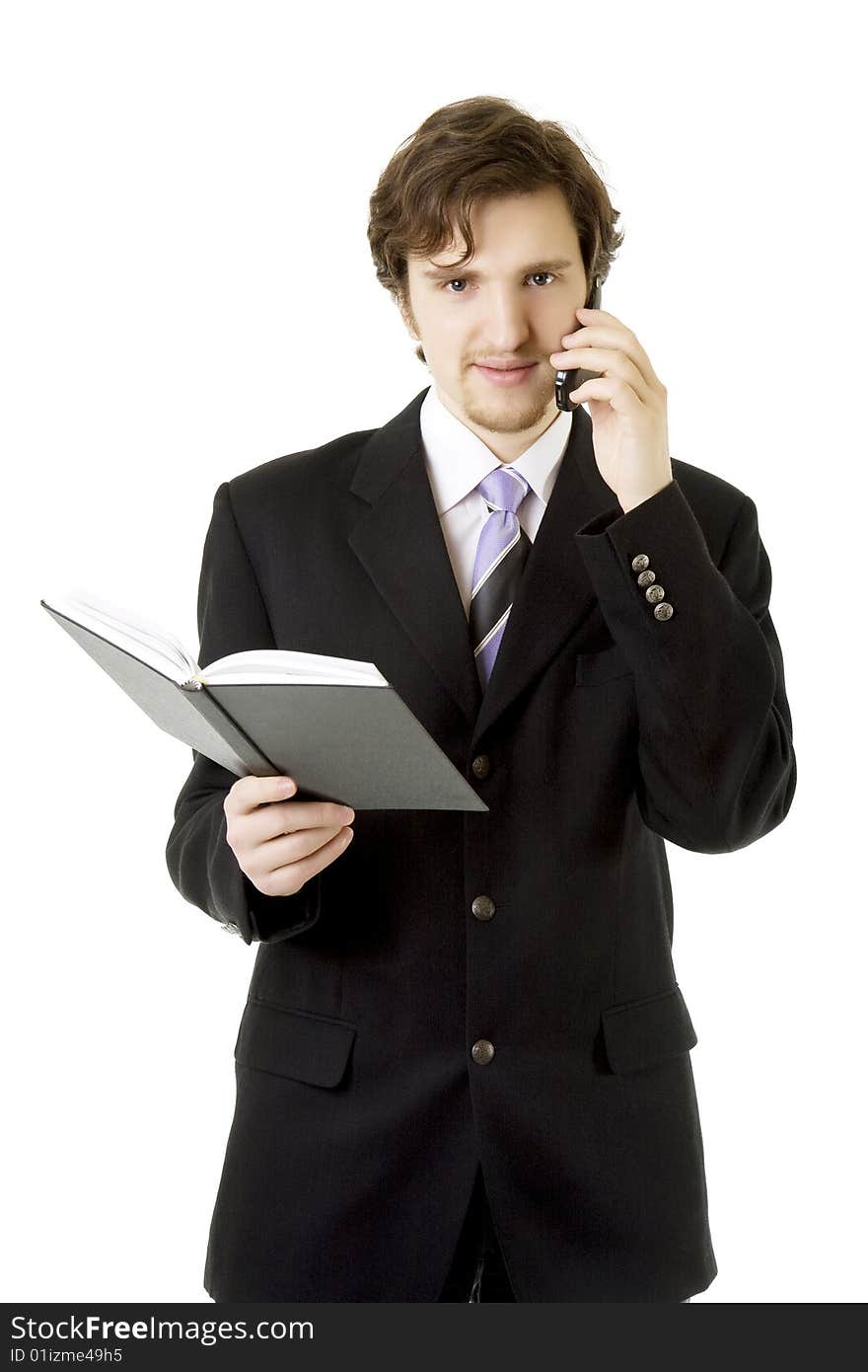 Image of the businessman, who is talking on the phone and looks at the daily. Image of the businessman, who is talking on the phone and looks at the daily