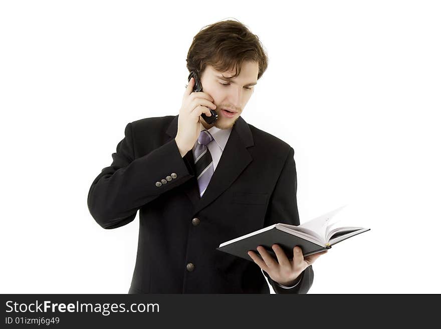 Image of the businessman, who is talking on the phone and looks at the daily. Image of the businessman, who is talking on the phone and looks at the daily