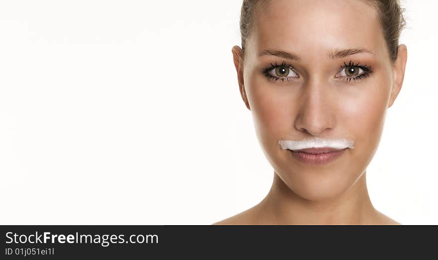 Pretty womans face with a milky beard over her lips