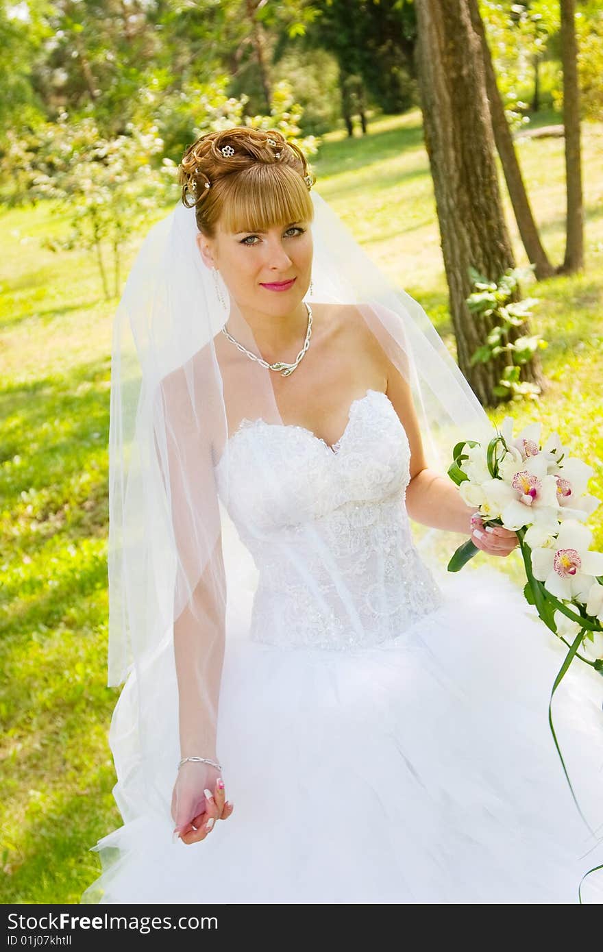 Pretty bride in the park with bouqet