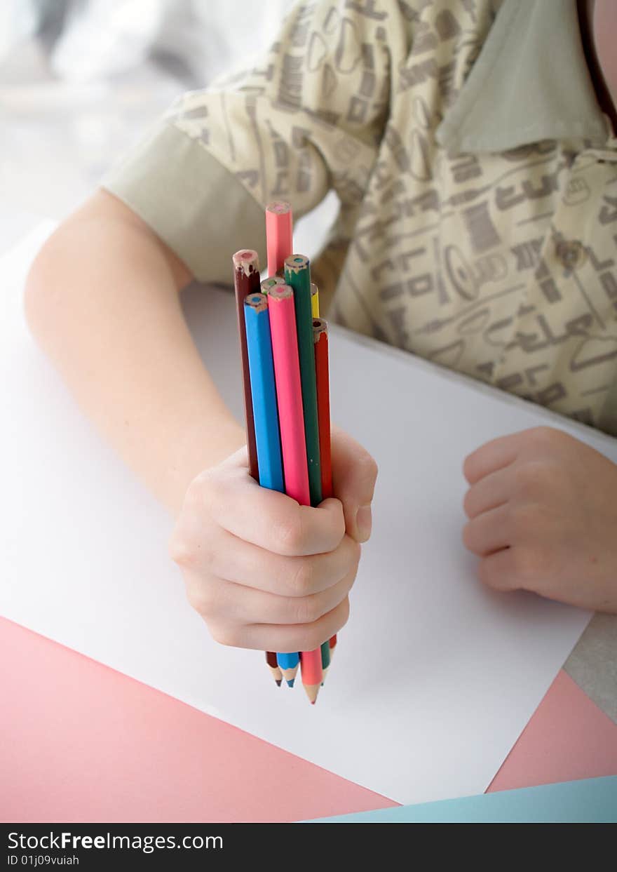 Boy draws pencils sitting for a table. Boy draws pencils sitting for a table