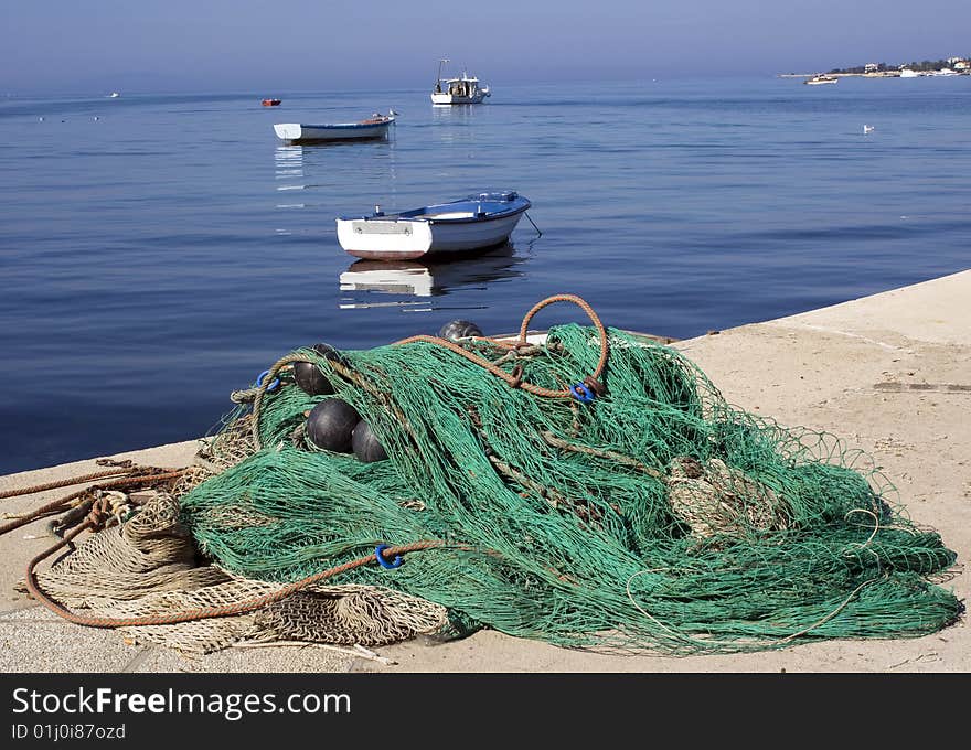 Picture taken in port of Novalja, island Pag, Croatia. Fishing net and fishing boats on Sunday. Picture taken in port of Novalja, island Pag, Croatia. Fishing net and fishing boats on Sunday.