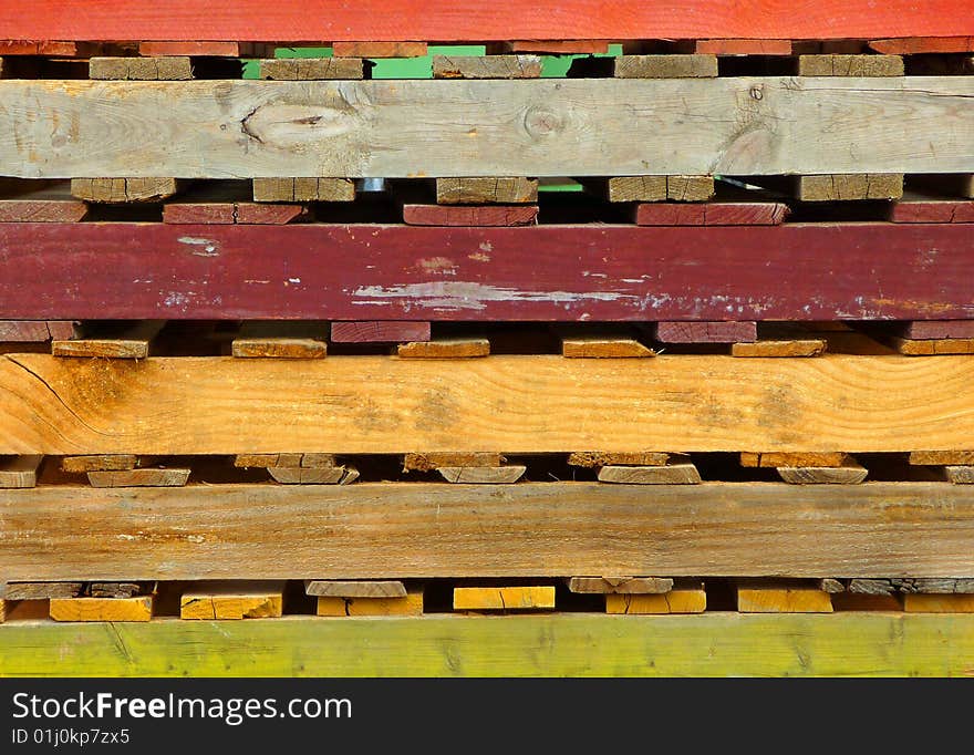 Close-up image of a stack of colorful wooden pallets. Close-up image of a stack of colorful wooden pallets.