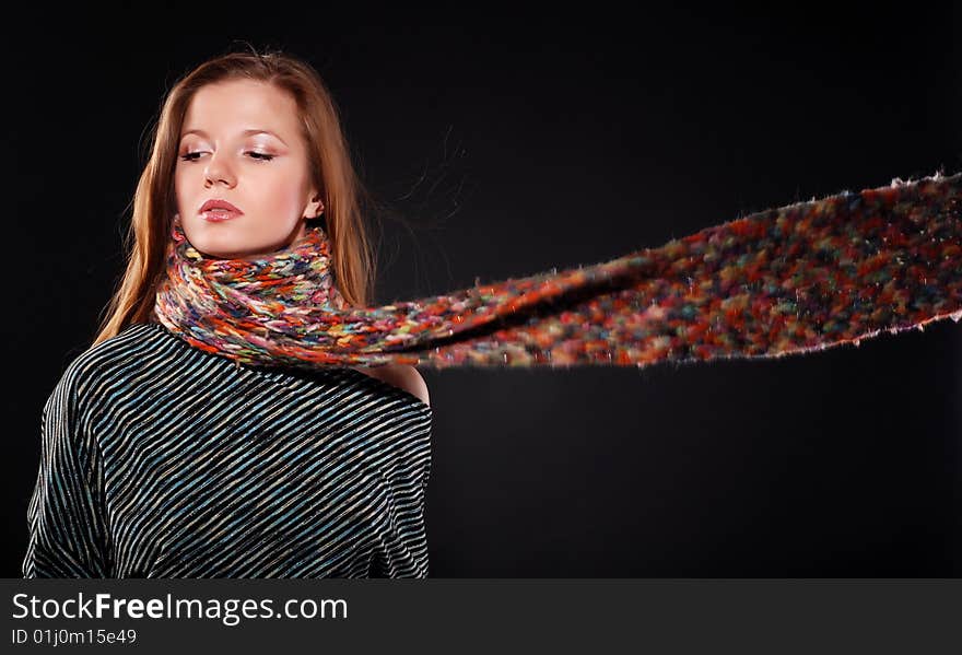 Young woman in color wool scarf at black background. Young woman in color wool scarf at black background