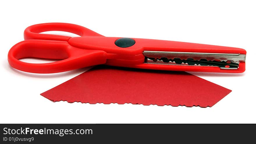 Red serrated scissors and cut paper. Red serrated scissors and cut paper