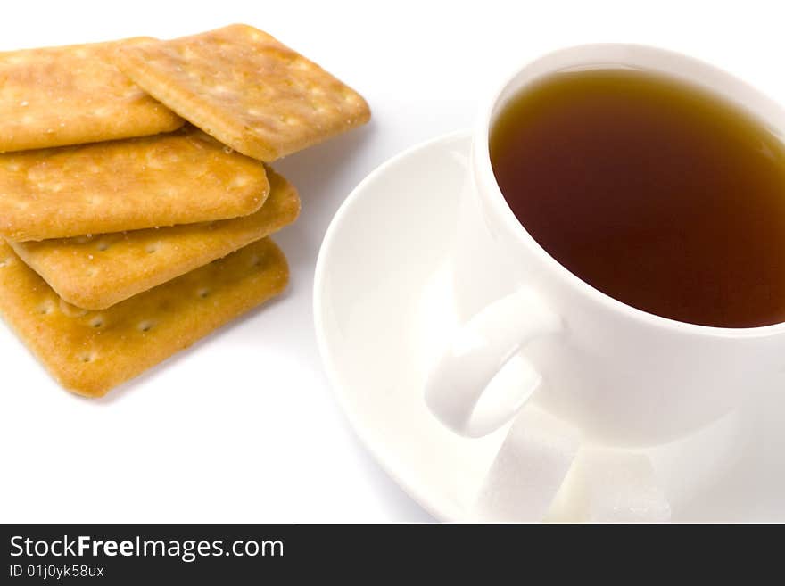 Cup of tea, sugar and cookies closeup on white