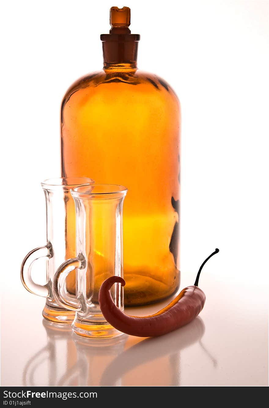 Bottle With Shiny Oil And A Chilly Pepper Beside.