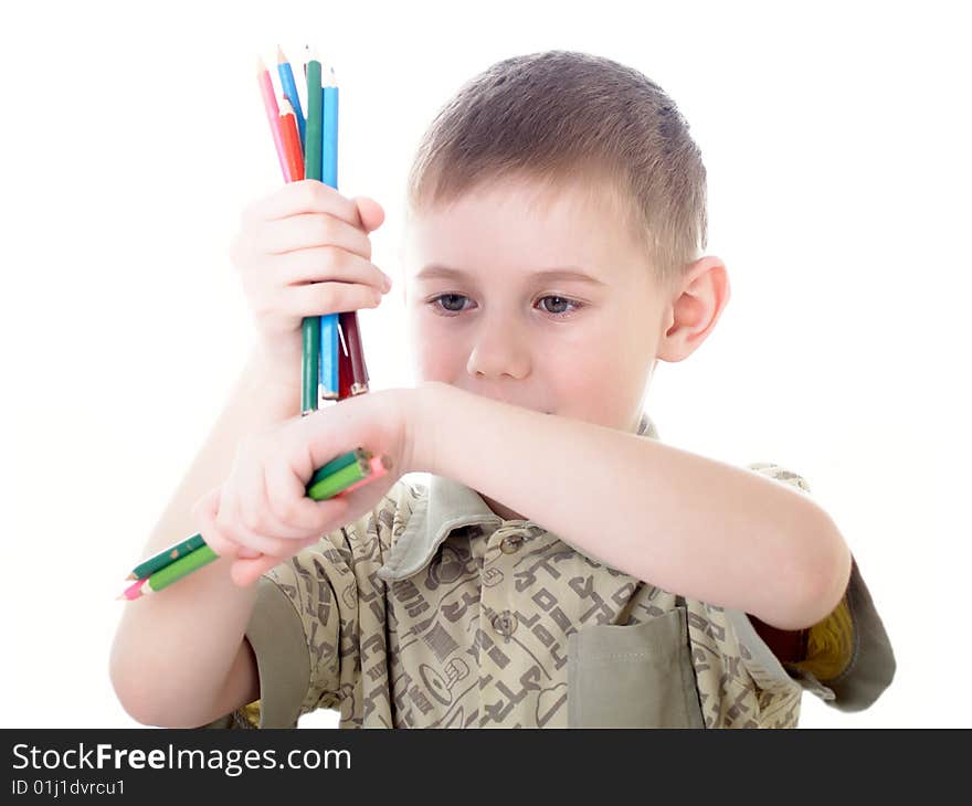 6 year old boy draws pencils sitting for a table. 6 year old boy draws pencils sitting for a table