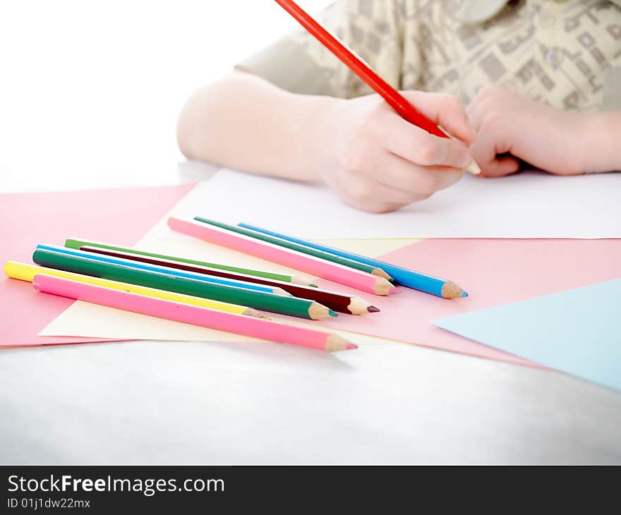 Boy draws pencils sitting for a table. Boy draws pencils sitting for a table