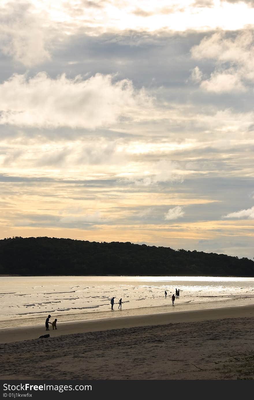 Sunset on a beach with people silhouettes. Sunset on a beach with people silhouettes