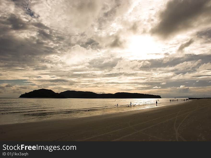 Sunset on a beach with people silhouettes. Sunset on a beach with people silhouettes