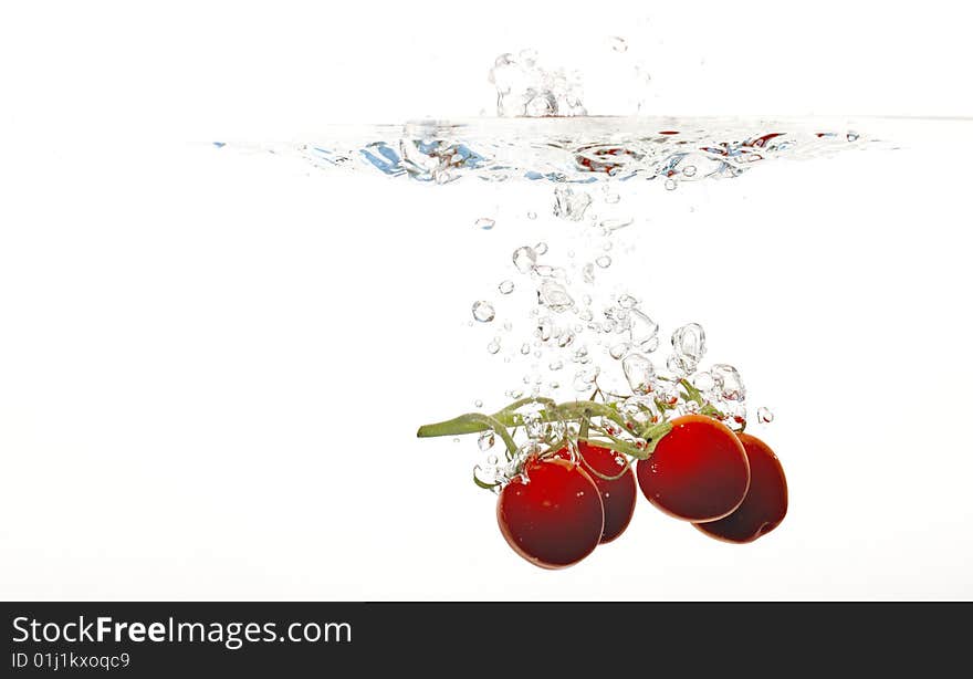 Tomatoes are falling into water. Tomatoes are falling into water