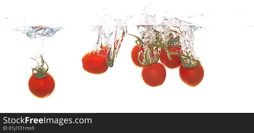 Tomatoes are falling into water. Tomatoes are falling into water