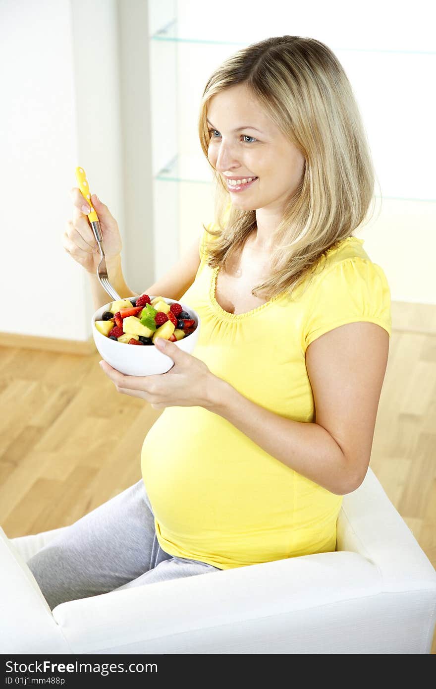 Pregnant woman is eating fruits