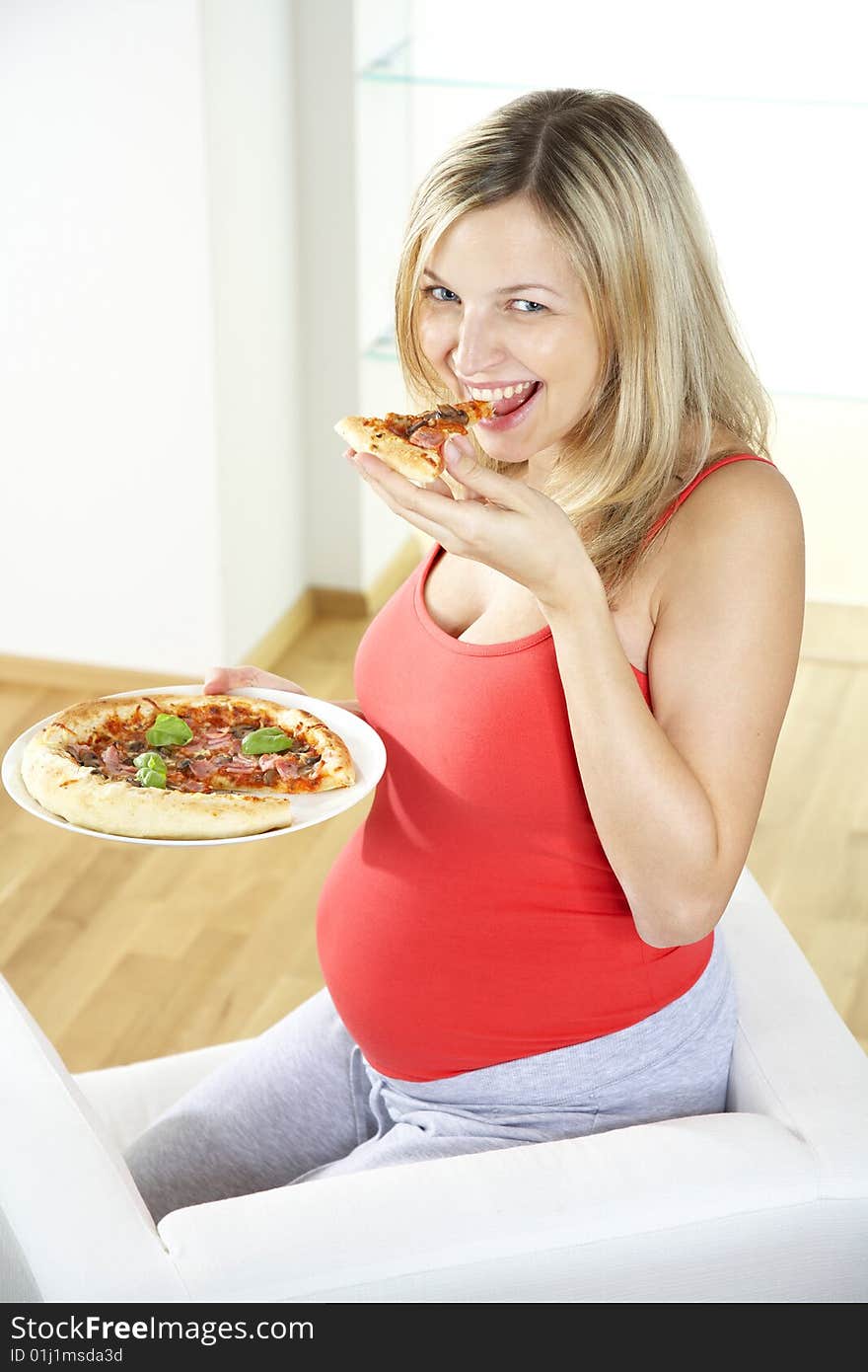 Young pregnant woman eating pizza