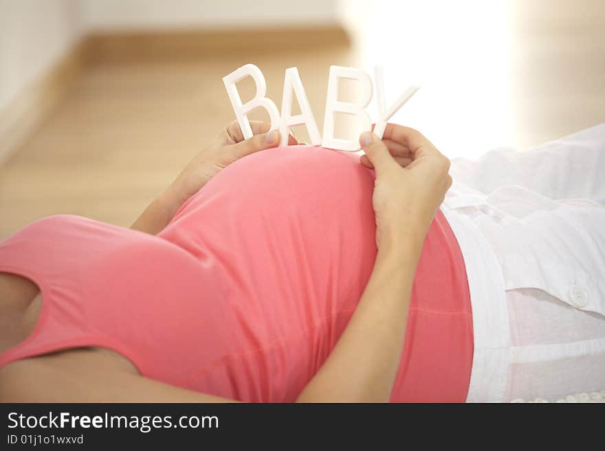 Pregnant woman keeps baby stroke on her belly. Pregnant woman keeps baby stroke on her belly