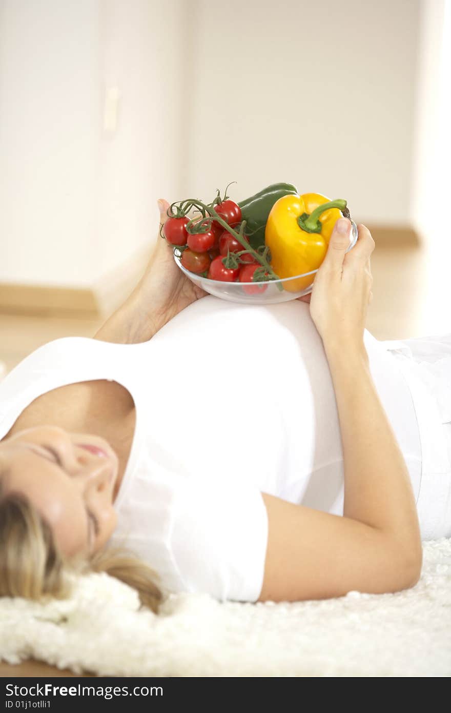 Young pretty pregnant woman with vegetables