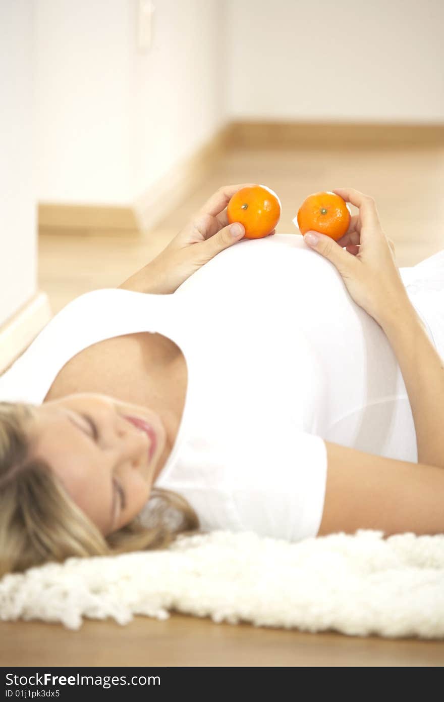 Young Pretty Pregnant Woman With Oranges