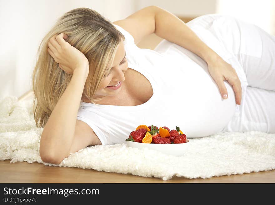 Young pretty pregnant woman with strawberries