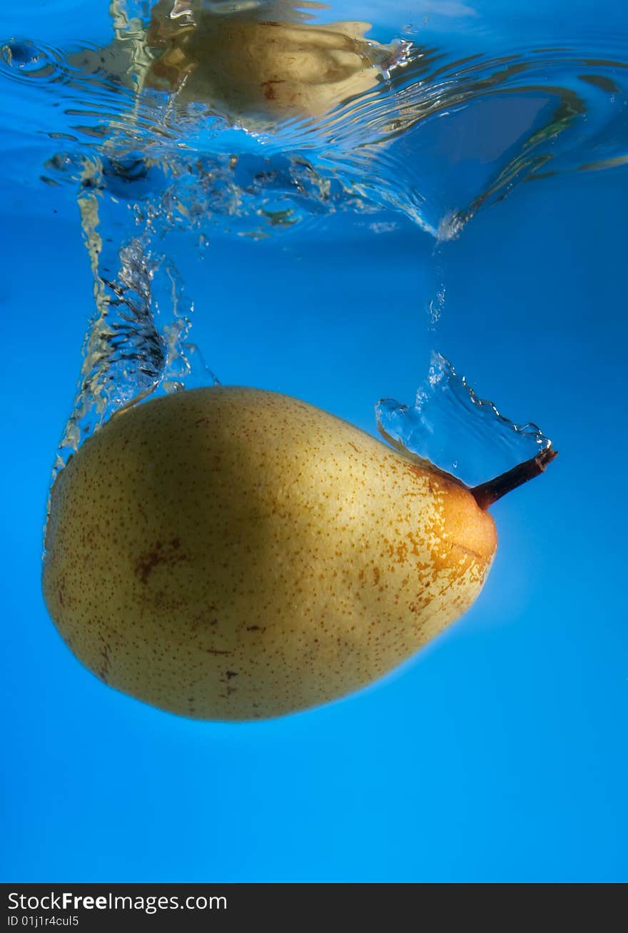 Pear in water on a blue background