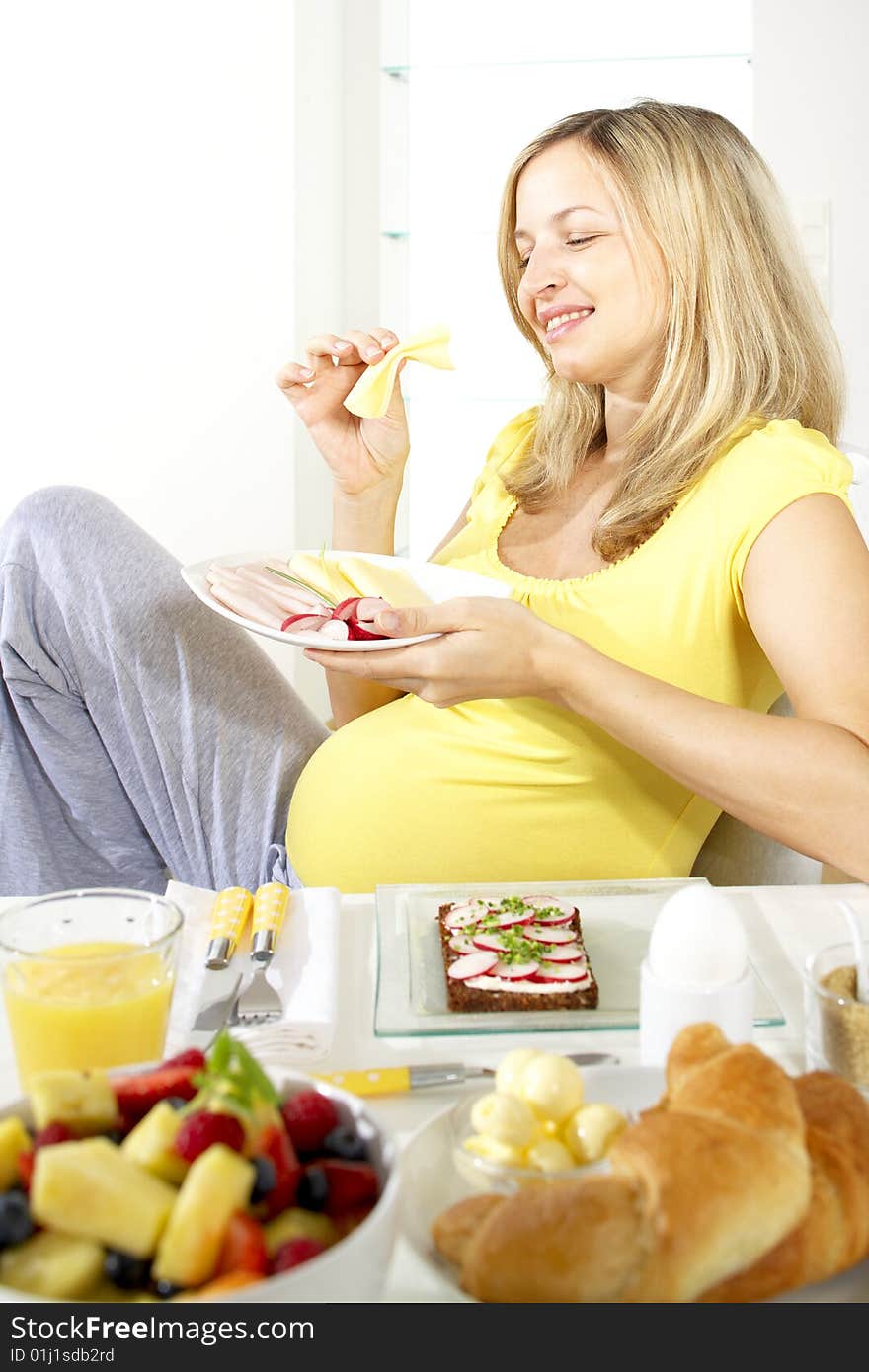 Young beautiful pregnant woman having breakfast. Young beautiful pregnant woman having breakfast