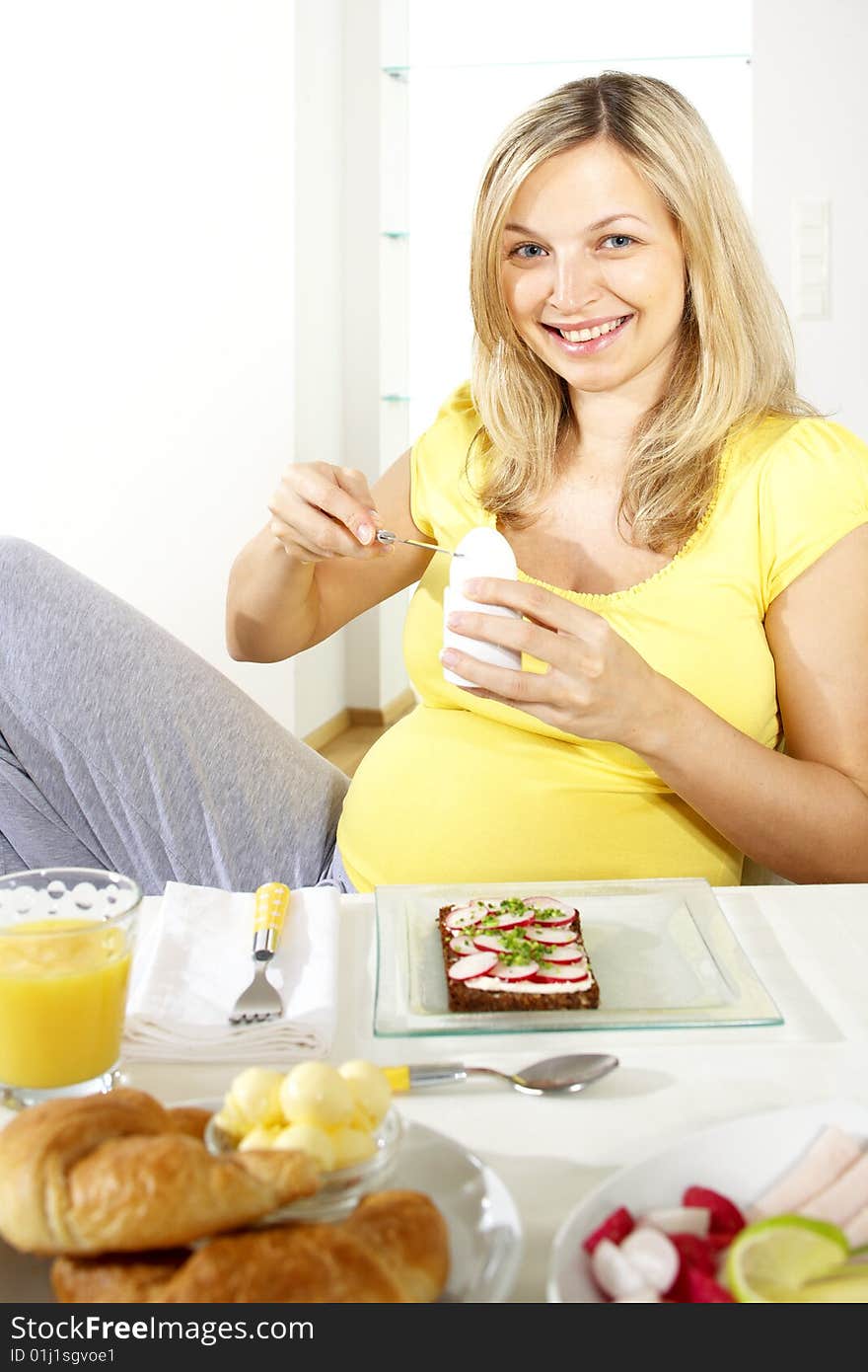 Young beautiful pregnant woman having breakfast. Young beautiful pregnant woman having breakfast