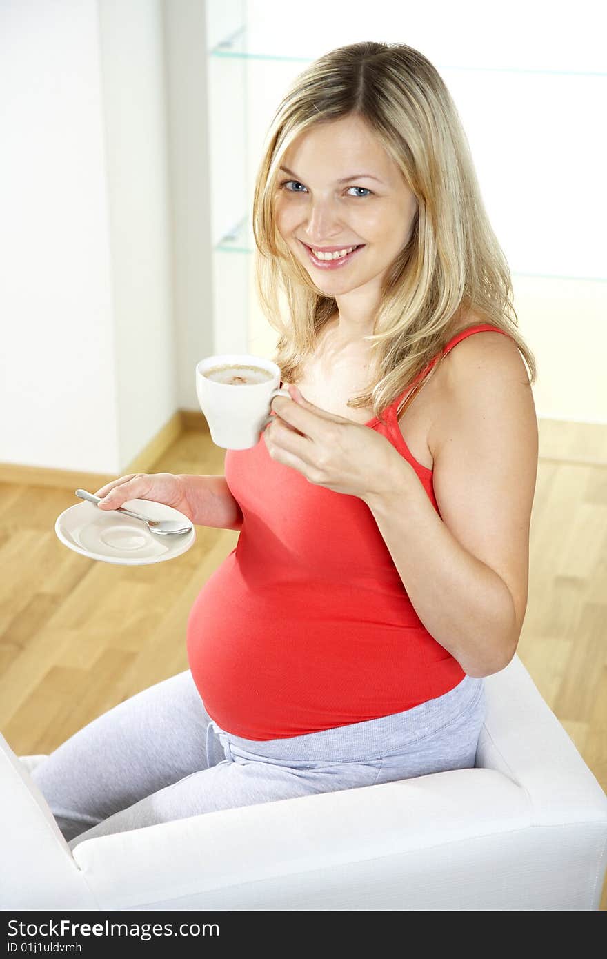 Pregnant woman is drinking coffee