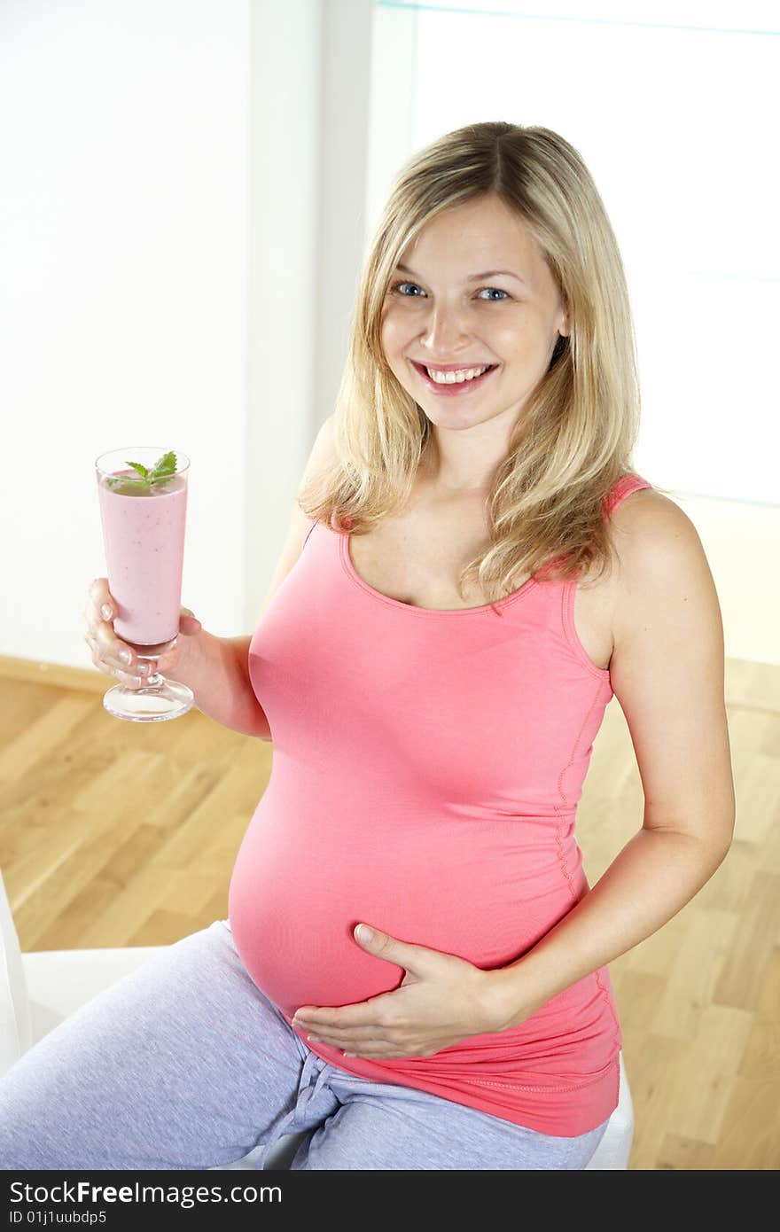 Young pregnant woman with milkshake