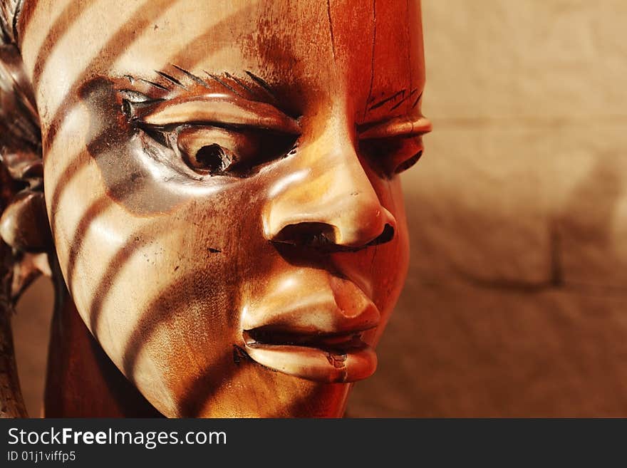 Ancient wooden sculpture from Africa on a sunlight.