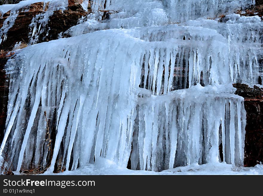 Hanging icicles formed by the melting snow over the cliff