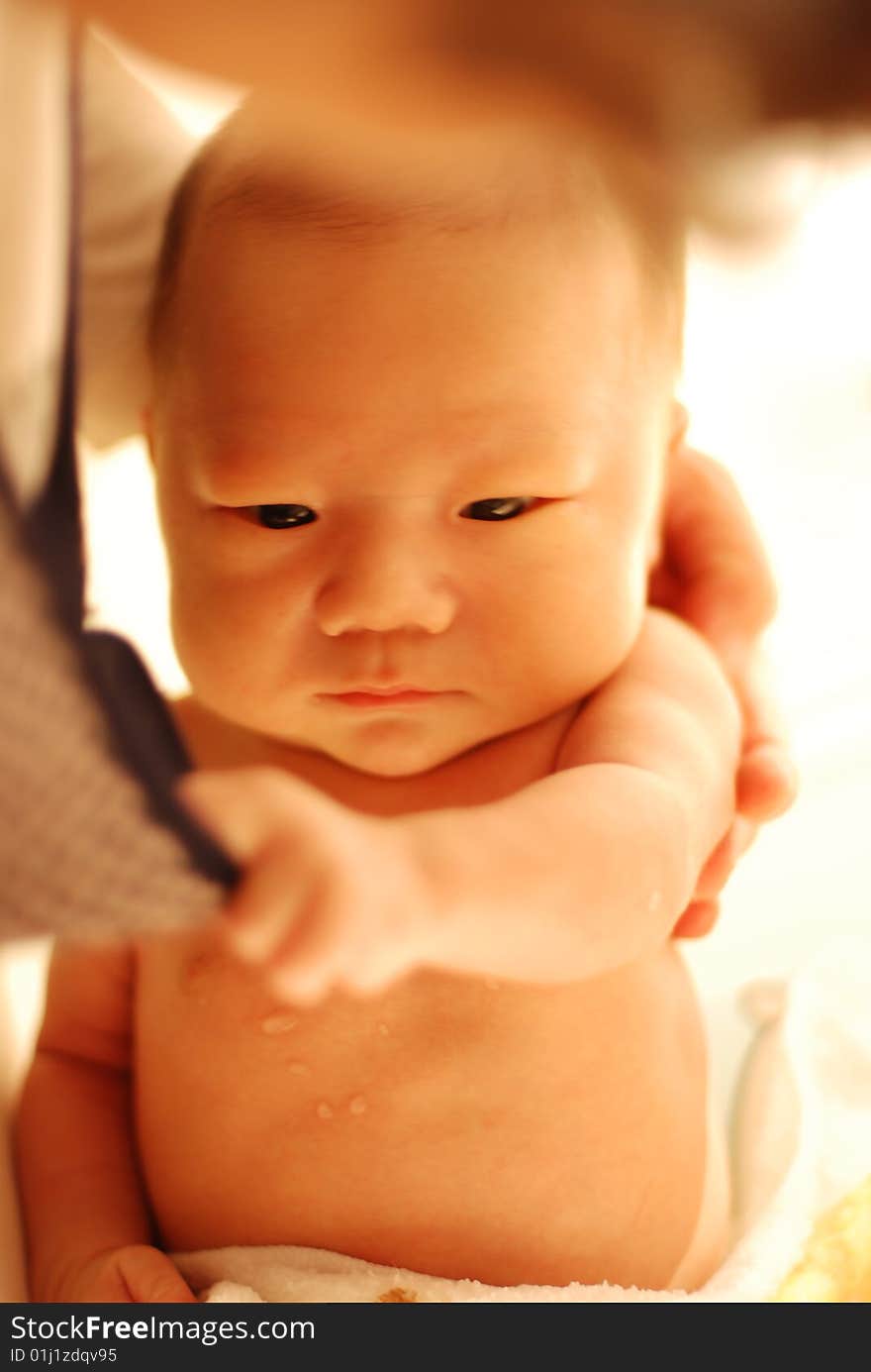 Cute baby boy holding mom's collar