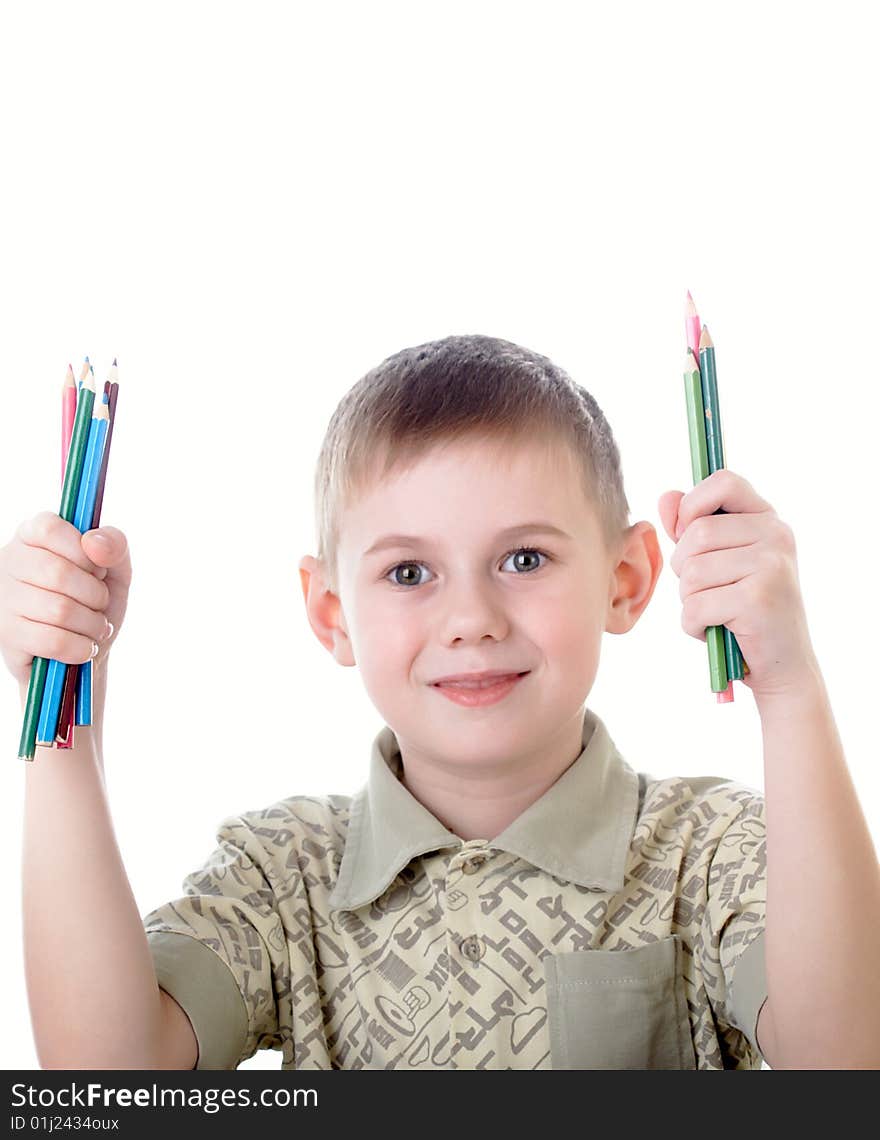 6 year old boy draws pencils sitting for a table. 6 year old boy draws pencils sitting for a table