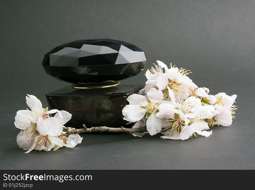 Perfume with flower on a black background