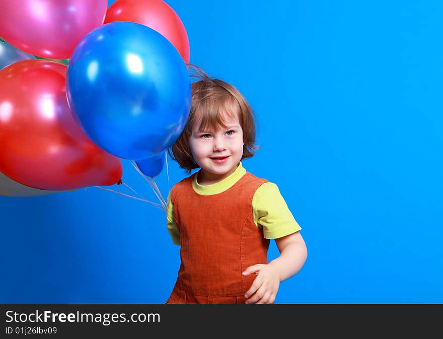 Little girl holding colorful balloons on a blue background. Little girl holding colorful balloons on a blue background